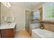 Bathroom features dual sinks, glass shower, soaking tub, and a large window for natural light at 8008 Battersea Ct, Waxhaw, NC 28173