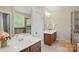 Bathroom boasts dual vanities, decorative mirror, tiled floors, and a separate shower and tub at 8008 Battersea Ct, Waxhaw, NC 28173