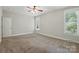 Spacious bedroom with neutral walls, plush carpet, natural light, and ceiling fan at 8008 Battersea Ct, Waxhaw, NC 28173
