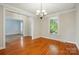 Bright dining room offers hardwood floors, a contemporary chandelier, and large sunlit windows at 8008 Battersea Ct, Waxhaw, NC 28173