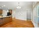 Open-concept dining room with hardwood floors, modern lighting, and a view of the kitchen at 8008 Battersea Ct, Waxhaw, NC 28173