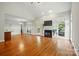 Open-concept living area with hardwood floors, fireplace, TV, and ample natural light from large windows at 8008 Battersea Ct, Waxhaw, NC 28173