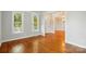 Sun-lit living room with hardwood floors, large windows, and classic trim and baseboards at 8008 Battersea Ct, Waxhaw, NC 28173