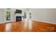 Spacious living room with hardwood floors, a cozy fireplace, and natural light from large windows at 8008 Battersea Ct, Waxhaw, NC 28173