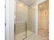 Modern bathroom with a glass shower and access to a walk-in closet at 8021 Lerwick Trl, Charlotte, NC 28269