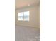 A bright bedroom features neutral walls, a window, and plush carpeting at 8021 Lerwick Trl, Charlotte, NC 28269
