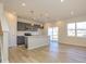 Open floor plan showcasing a modern kitchen with an island and gray cabinets flowing into the bright living area at 8021 Lerwick Trl, Charlotte, NC 28269