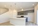 Open kitchen boasts a spacious island, stainless steel microwave, gray cabinets, and modern pendant lights at 8021 Lerwick Trl, Charlotte, NC 28269