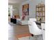 Cozy living and dining area with modern decor, including white sofa, colorful artwork, and light wood floors at 8021 Lerwick Trl, Charlotte, NC 28269