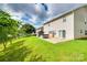 Spacious backyard featuring lush lawn, mature trees, hot tub, storage shed, and sliding glass doors to home at 10071 Highland Creek Cir, Indian Land, SC 29707