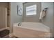 Bathroom featuring soaking tub and window, with glass shower in corner at 10071 Highland Creek Cir, Indian Land, SC 29707