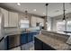 Bright kitchen boasting granite countertops, stainless steel appliances, stylish fixtures and blue and white cabinets at 10071 Highland Creek Cir, Indian Land, SC 29707