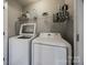 Functional laundry room with a washer, dryer, and shelving for storage and cleaning supplies at 10071 Highland Creek Cir, Indian Land, SC 29707