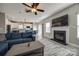Spacious living room with a fireplace, blue sofa, and view of the modern kitchen at 10071 Highland Creek Cir, Indian Land, SC 29707