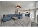 Open living room flows into the kitchen with a cozy blue sofa and a neutral area rug at 10071 Highland Creek Cir, Indian Land, SC 29707