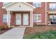 Brick townhome exterior with a covered front entrance, colorful door wreath, and landscaped yard at 102 Brandywine Ne Dr # R3, Conover, NC 28613