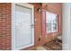 Up-close view of the front door, window with red shutters, and small front yard at 102 Brandywine Ne Dr # R3, Conover, NC 28613