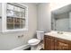 Well-lit bathroom with a wood vanity and a large mirror, complemented by a window at 1024 Eaglewood Ave, Charlotte, NC 28212