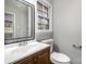 Bathroom featuring a wood vanity, large mirror, and plenty of natural light at 1024 Eaglewood Ave, Charlotte, NC 28212