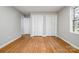 Bedroom with hardwood floors, a closet, and natural light streaming through the window at 1024 Eaglewood Ave, Charlotte, NC 28212