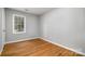 Bedroom with hardwood floors, bright natural light from window, and neutral walls at 1024 Eaglewood Ave, Charlotte, NC 28212