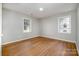 Light-filled bedroom with hardwood floors and two windows, offering ample natural light at 1024 Eaglewood Ave, Charlotte, NC 28212