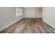 Spacious living room featuring wood-look flooring, neutral walls, and natural light from a large window at 1024 Eaglewood Ave, Charlotte, NC 28212