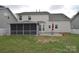 Exterior view of the home showcasing a screened-in porch and patio in the backyard at 1100 Millbank Dr, Matthews, NC 28104