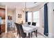 Sunlit dining room with bay window, chandelier, and access to kitchen and laundry room at 1100 Millbank Dr, Matthews, NC 28104