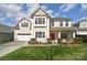 Charming two-story home featuring a well-manicured lawn and a striking red front door at 1100 Millbank Dr, Matthews, NC 28104