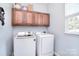 Functional laundry room equipped with a washer, dryer, and upper cabinets for storage at 1100 Millbank Dr, Matthews, NC 28104