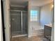 Bathroom featuring gray tile and a combined shower and soaking tub, with a large window for natural light at 117 High Rock Ct # 9, Statesville, NC 28677