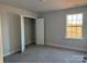 Bedroom with neutral walls and gray carpet, featuring walk-in closet and large window at 117 High Rock Ct # 9, Statesville, NC 28677