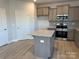 Kitchen featuring an island with granite countertops, stainless appliances, and gray cabinets at 117 High Rock Ct # 9, Statesville, NC 28677