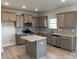 Open kitchen features stainless steel appliances, gray cabinets, granite countertops, tile backsplash, and a center island at 117 High Rock Ct # 9, Statesville, NC 28677