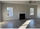 Bright and airy living room showcasing a fireplace, ceiling fan, and natural light from large windows at 117 High Rock Ct # 9, Statesville, NC 28677