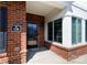 Inviting covered brick porch with a black front door and large window at 126 Adelaide Way, Rock Hill, SC 29732