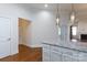 Kitchen island with granite countertops and white cabinets adjacent to living area with a fireplace at 126 Adelaide Way, Rock Hill, SC 29732