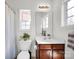 Bathroom featuring a pedestal sink, a toilet, a framed mirror, and a window at 14946 Shinner Dr, Huntersville, NC 28078