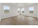 Bright bedroom with hardwood floors, white walls, and multiple windows providing natural light at 2016 Bramble Hedge Rd # 3277, Indian Trail, NC 28079