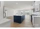 Open-concept kitchen with a navy island, white cabinets, stainless steel appliances, and hardwood floors at 2016 Bramble Hedge Rd # 3277, Indian Trail, NC 28079