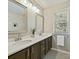 Bathroom with dual sinks, framed mirrors, and wood cabinets at 20313 Queensdale Dr, Cornelius, NC 28031