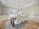 This dining room features wood floors, light colored walls, and a decorative ceiling with a modern light fixture at 20313 Queensdale Dr, Cornelius, NC 28031