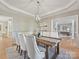 This dining room is open to the office and features light walls, wood floors, and a modern light fixture at 20313 Queensdale Dr, Cornelius, NC 28031