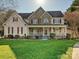 Inviting two-story home with a stone facade, a covered front porch, and landscaped lawn at 20313 Queensdale Dr, Cornelius, NC 28031