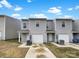 Charming townhomes with attached garages and gray siding, set on a concrete driveway beneath a bright blue sky at 217 Century Dr, Salisbury, NC 28147