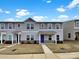 Inviting townhome exteriors featuring gray siding, blue doors, and manicured front lawns under a partly cloudy sky at 217 Century Dr, Salisbury, NC 28147