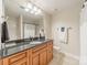 Well-lit bathroom featuring a granite countertop vanity, mirror, and shower with curtain at 300 W 5Th St # 344, Charlotte, NC 28202