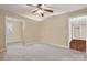 Bright bedroom with neutral walls, ceiling fan, and a doorway leading to additional rooms for flexible living at 4006 Sincerity Rd, Monroe, NC 28110