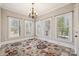 Bright dining room with large windows, neutral walls, decorative rug, and elegant chandelier at 4006 Sincerity Rd, Monroe, NC 28110